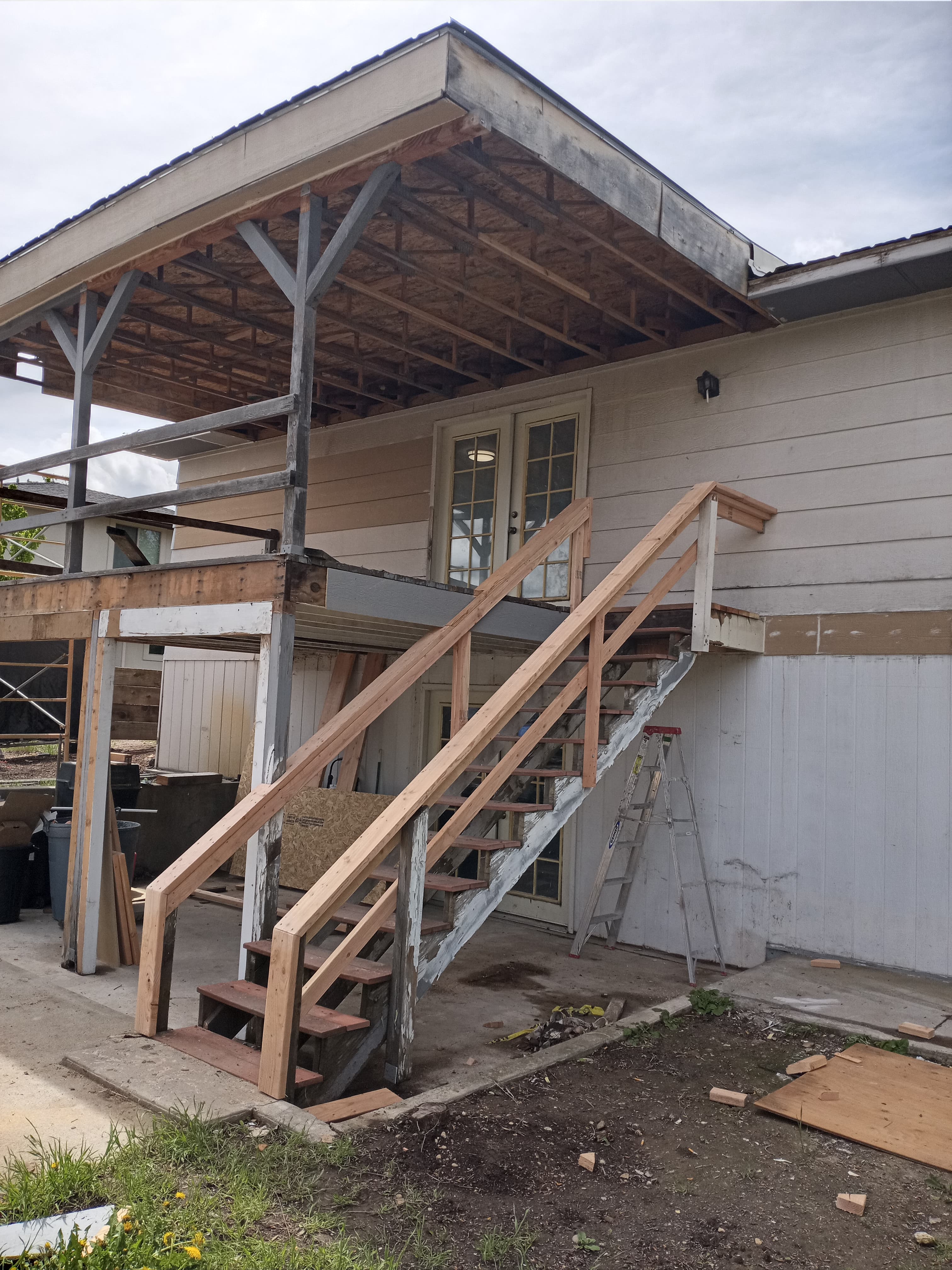 Two story house with back patio during the remodel of the rotted stairs