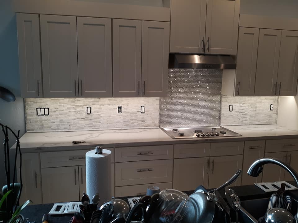 Kitchen with white cabinets and shiny tile installed above the stove
