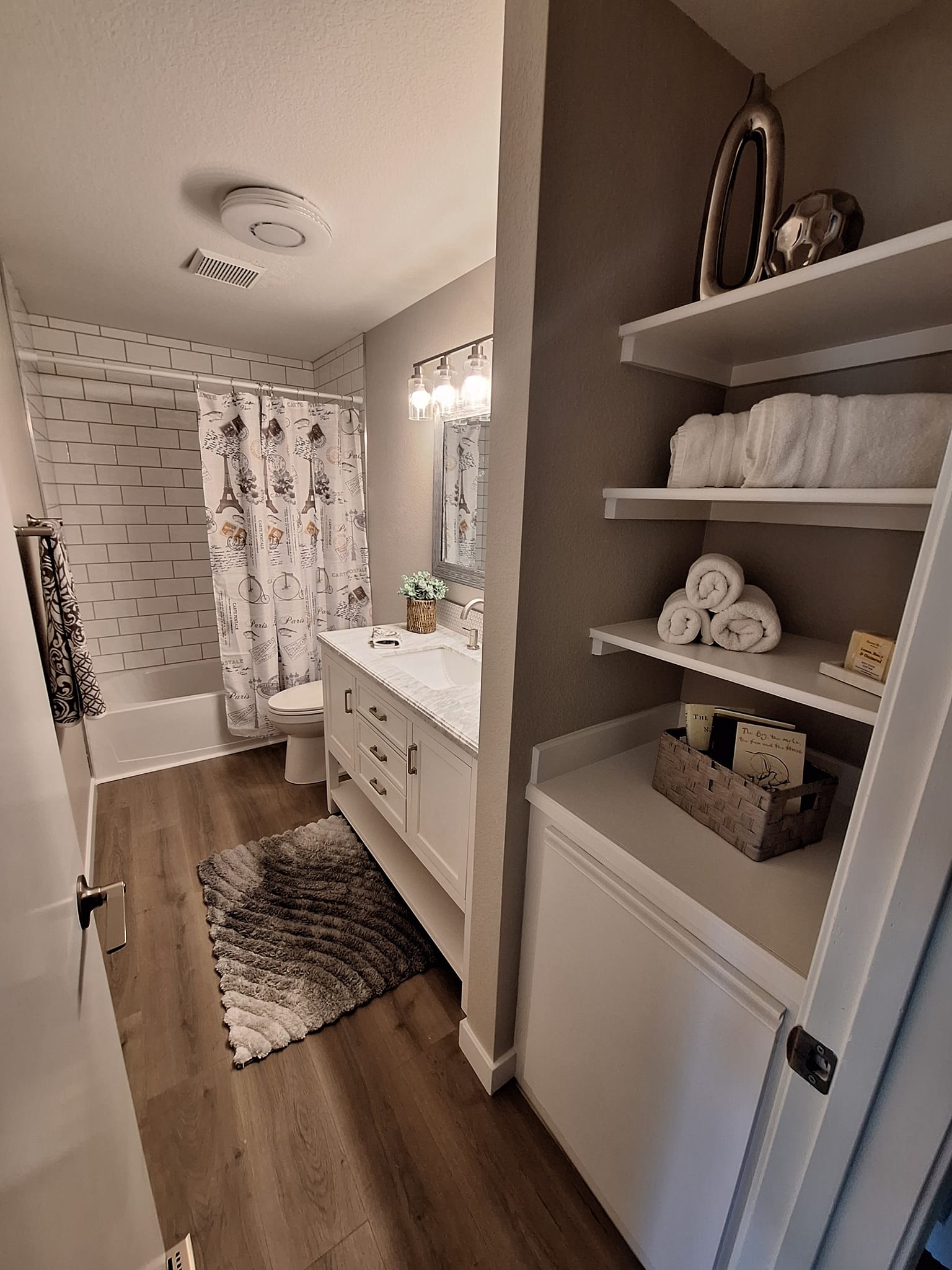 Bathroom with white cabinets and wood textured vinyl flooring