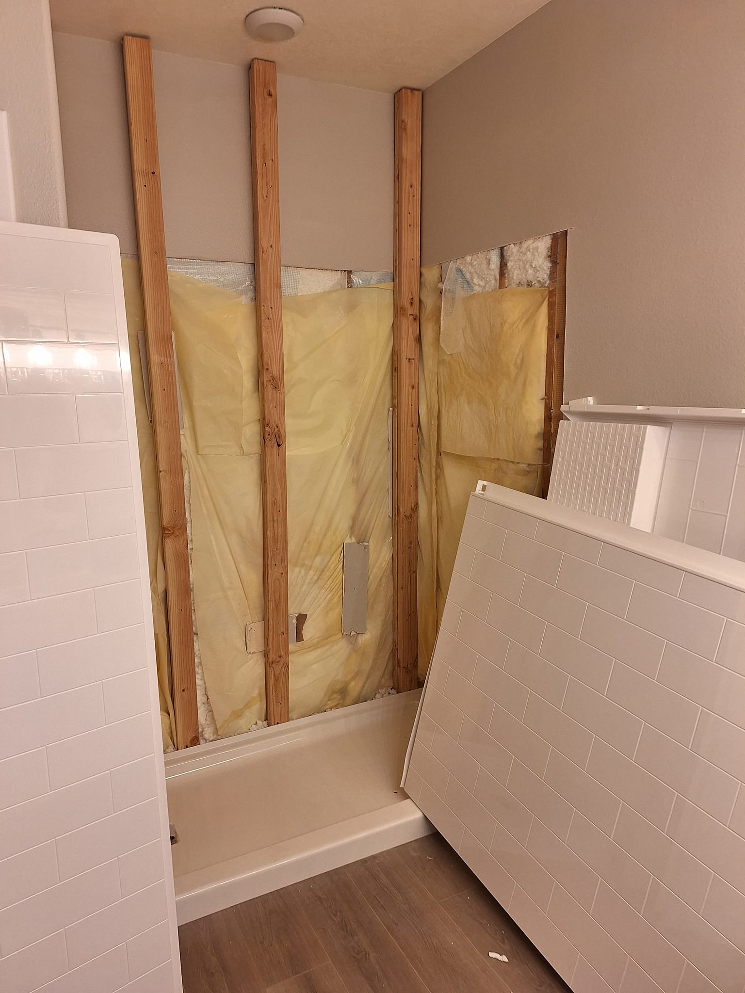Bathroom before remodel, shower removed and wood exposed