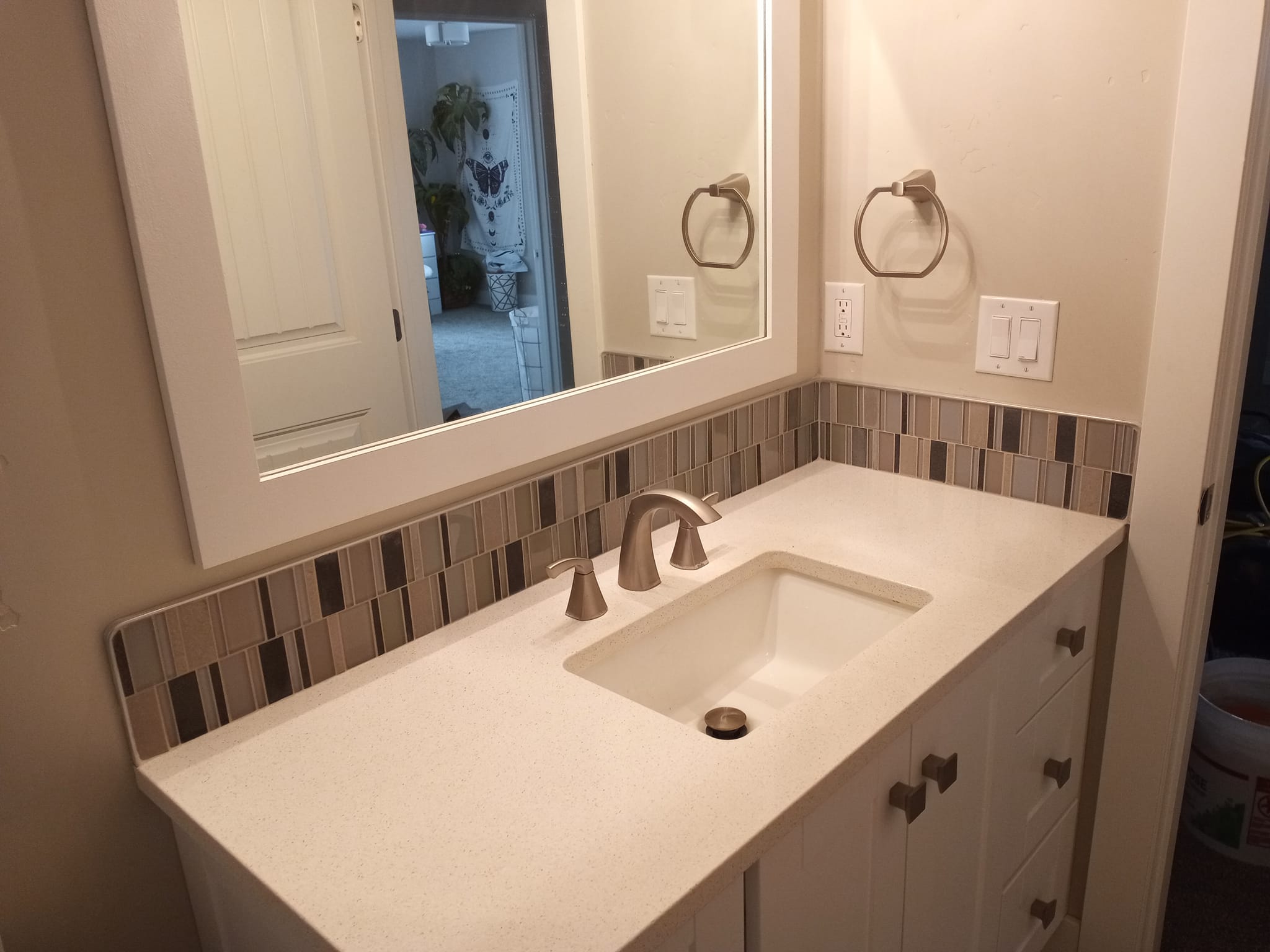 Bathroom vanity updated with new faucet, counter top, mirror and backsplash