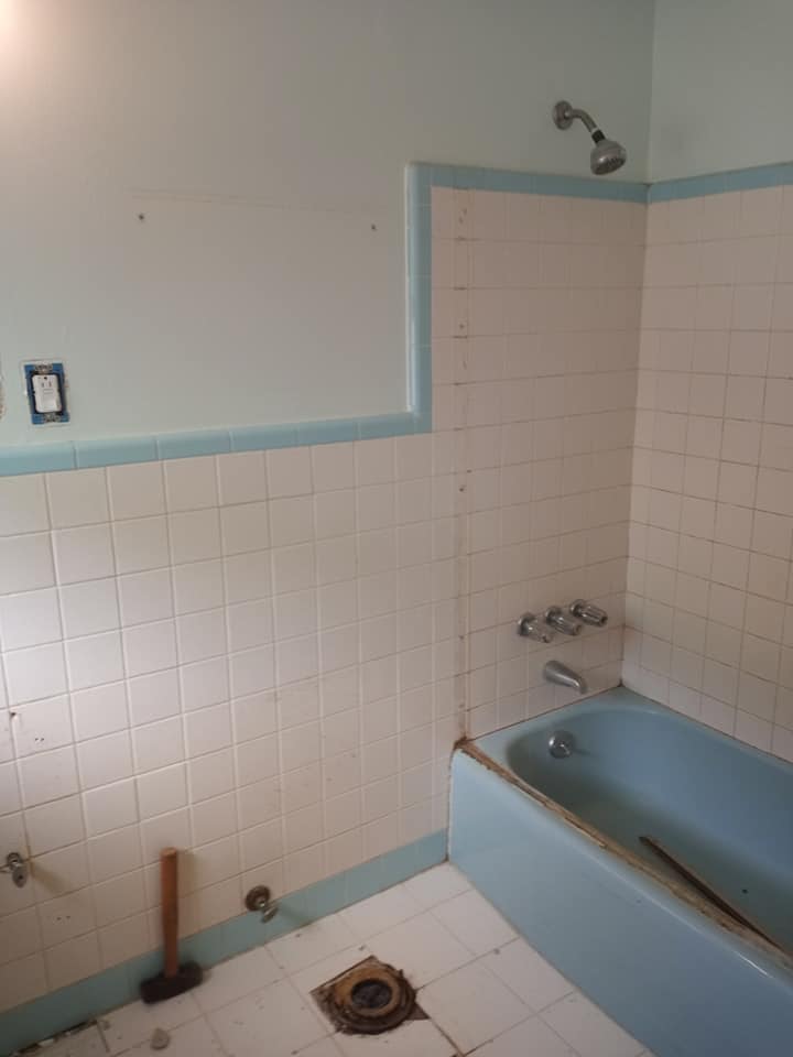 Bathroom with old, dirty tile, missing the vanity and toilet