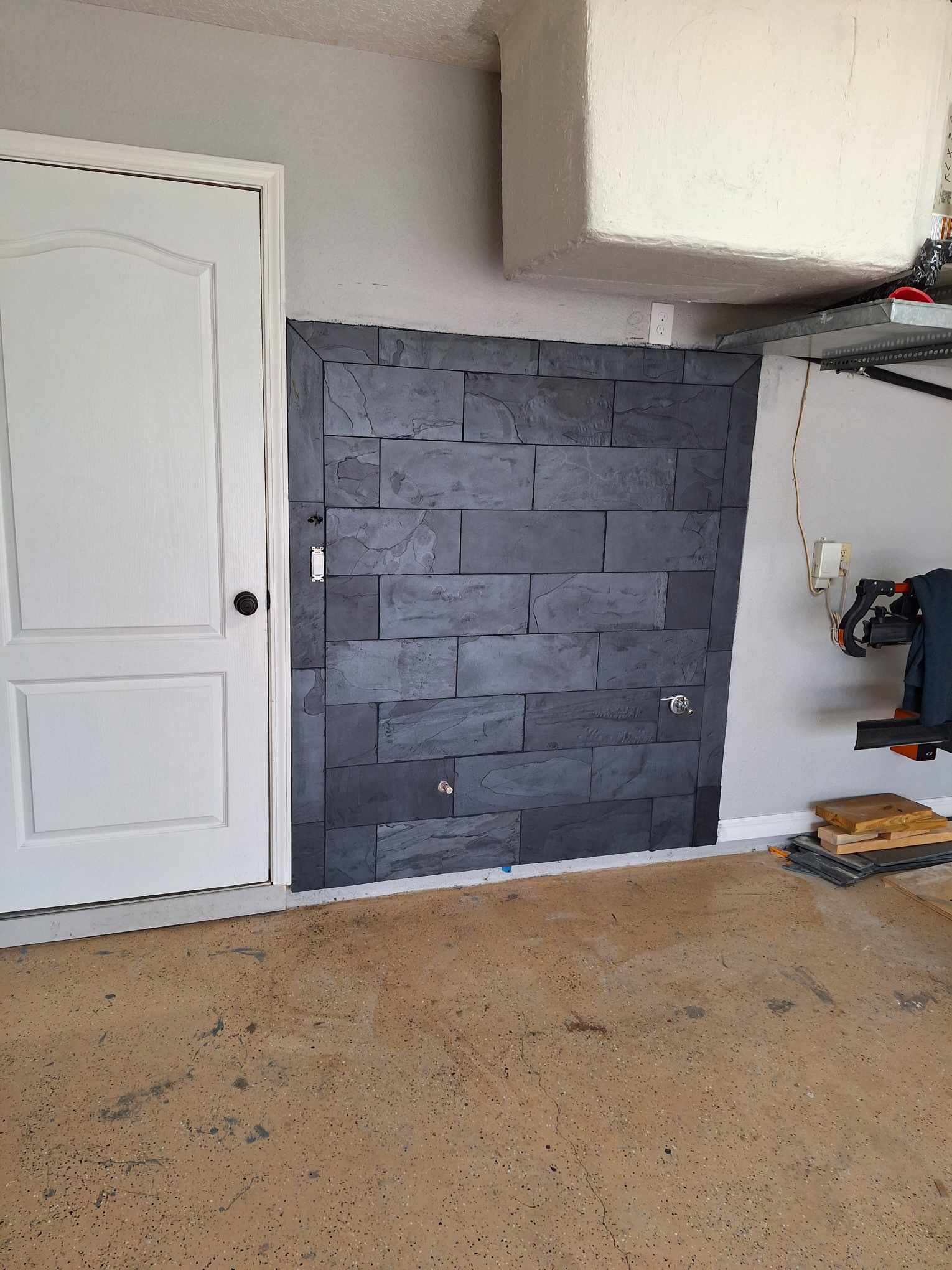 Custom black tile area on wall inside a garage
