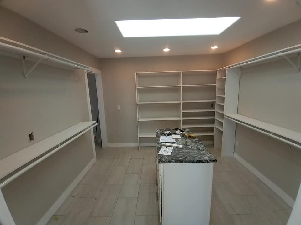 Large, empty closet with island and new white shelves