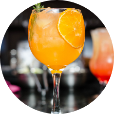 A cocktail with an orange slice and ice cubes