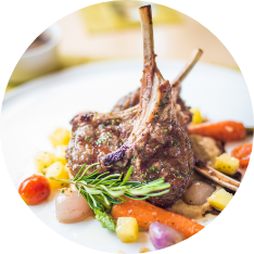 Rack of lamb surrounded by cooked vegetables
