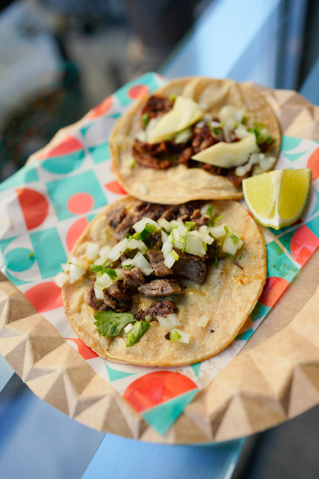 Two flat tacos with steak and onions on a plate